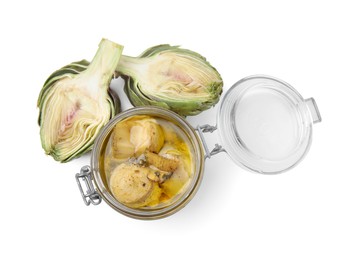 Open jar of delicious artichokes pickled in olive oil and fresh vegetables on white background, top view