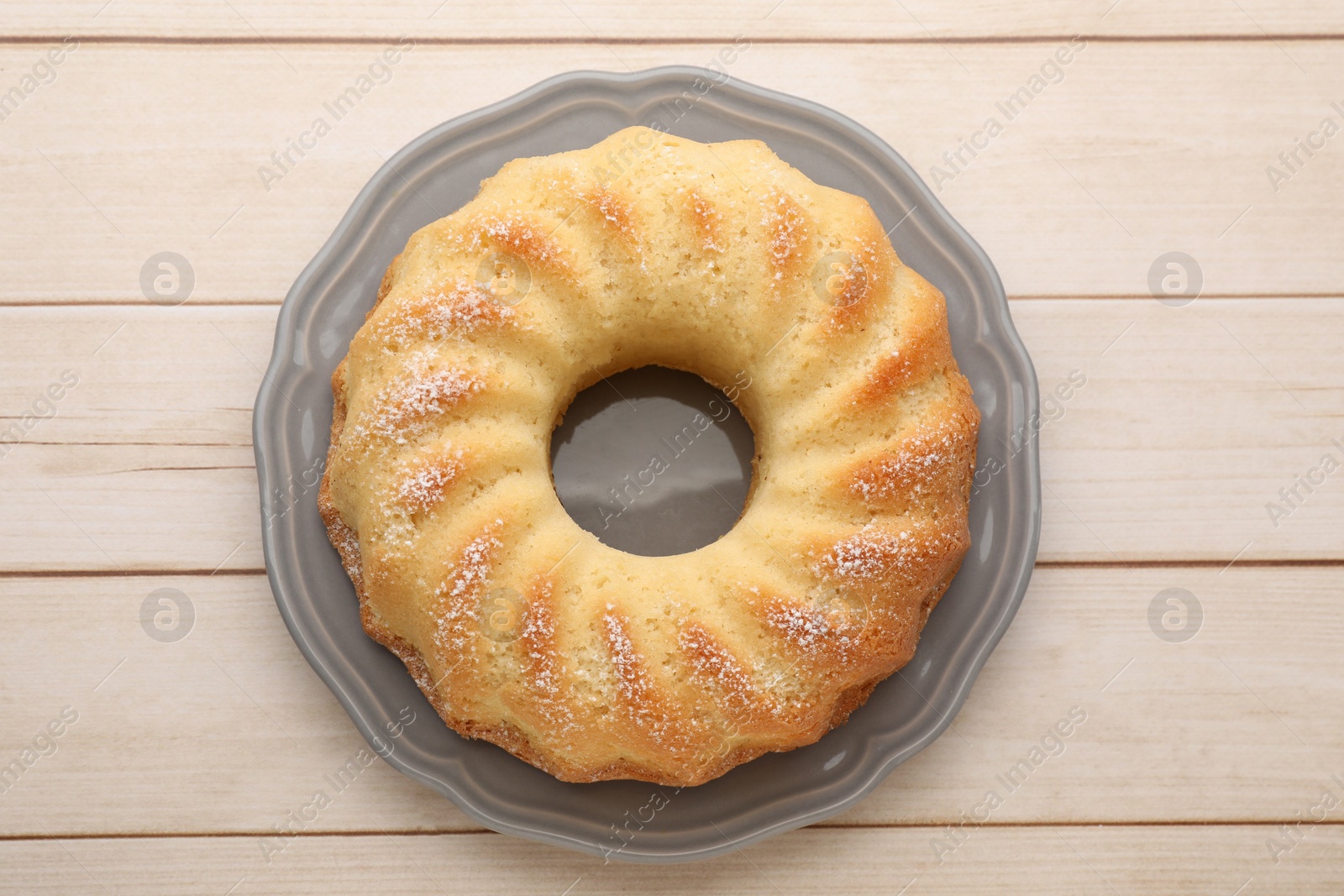 Photo of Delicious sponge cake on wooden table, top view