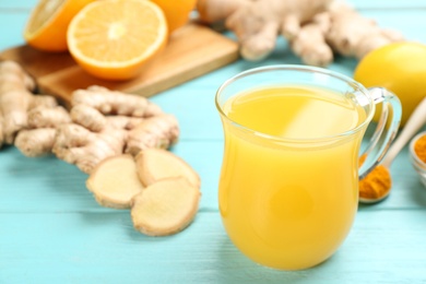 Photo of Immunity boosting drink and ingredients on turquoise wooden table, closeup