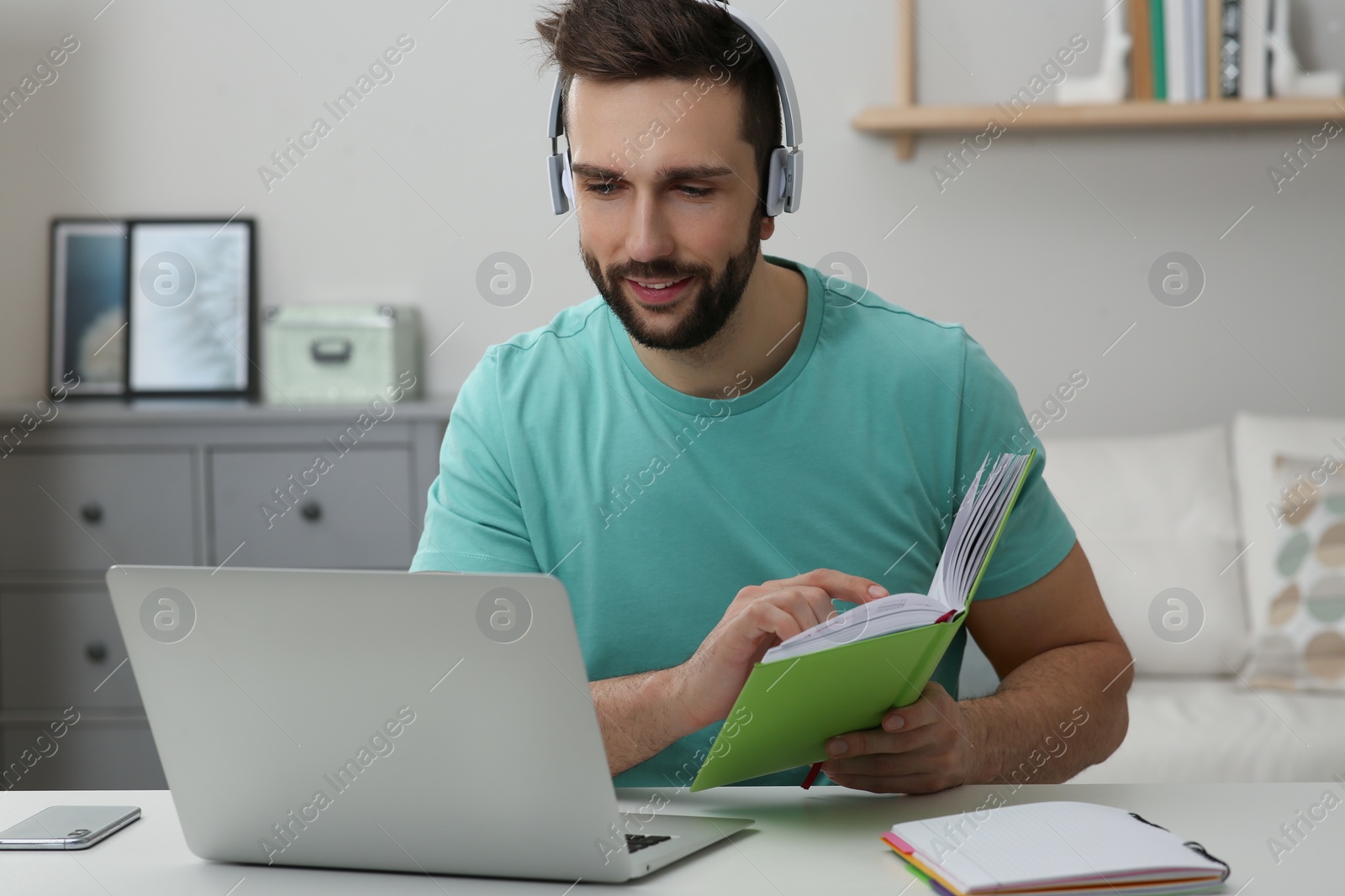 Photo of Online test. Man studying with laptop at home