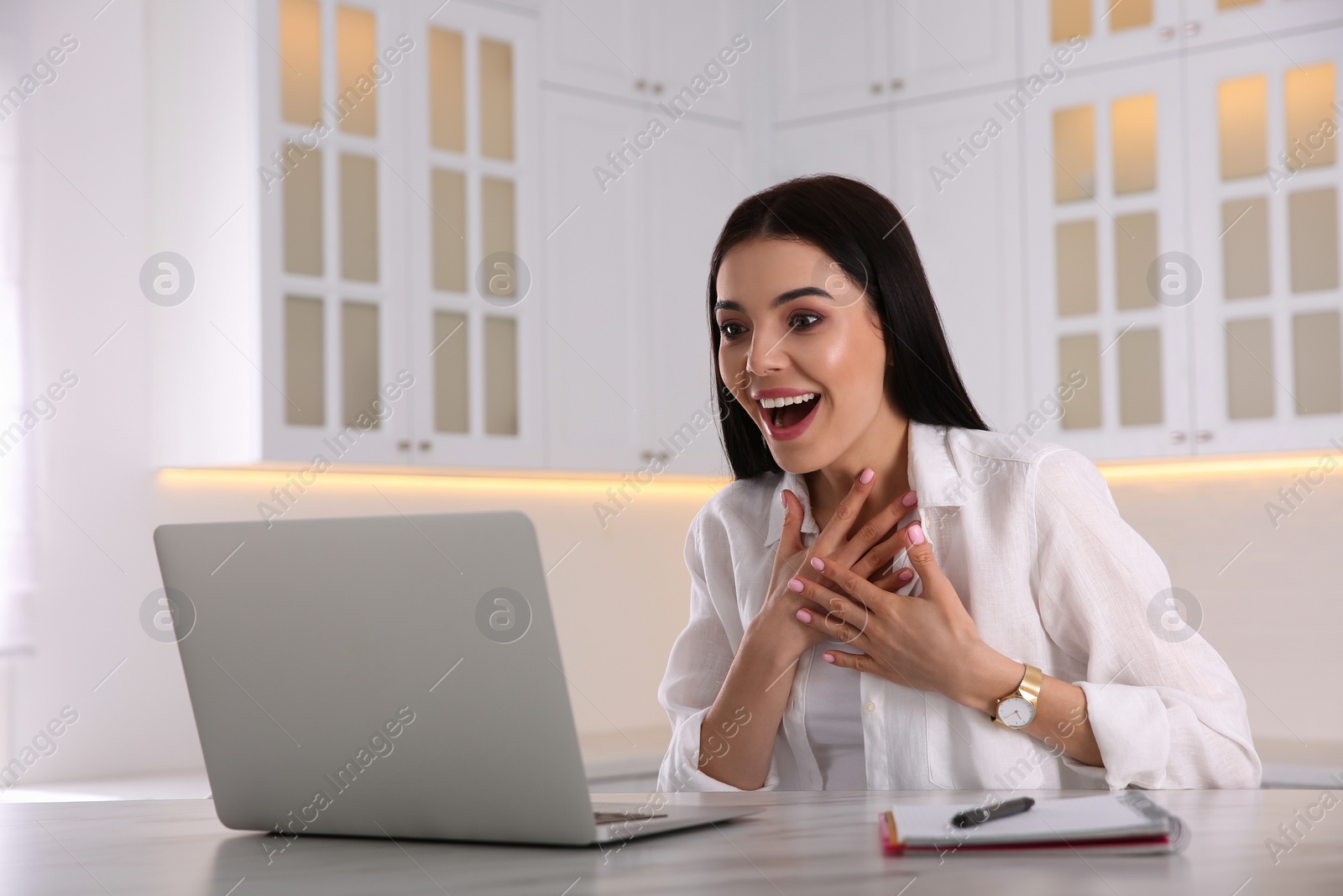 Photo of Emotional woman participating in online auction using laptop at home