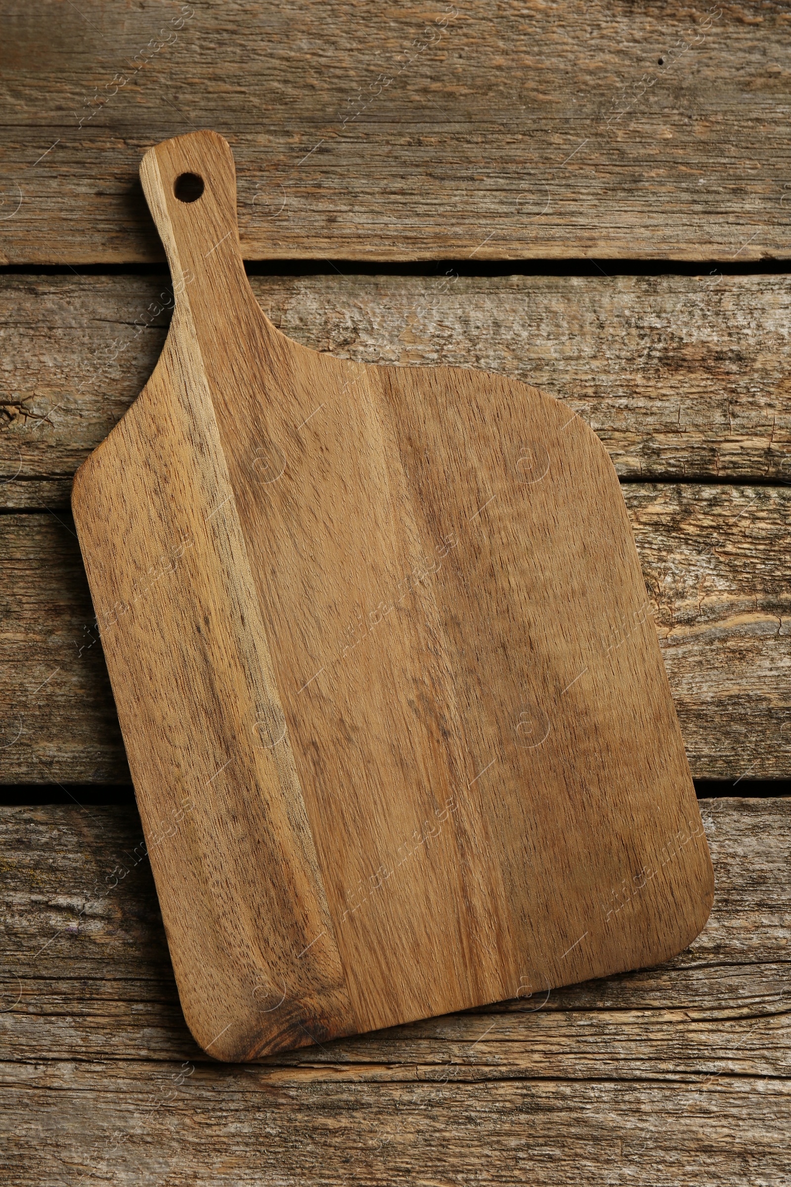 Photo of One new cutting board on old wooden table, top view