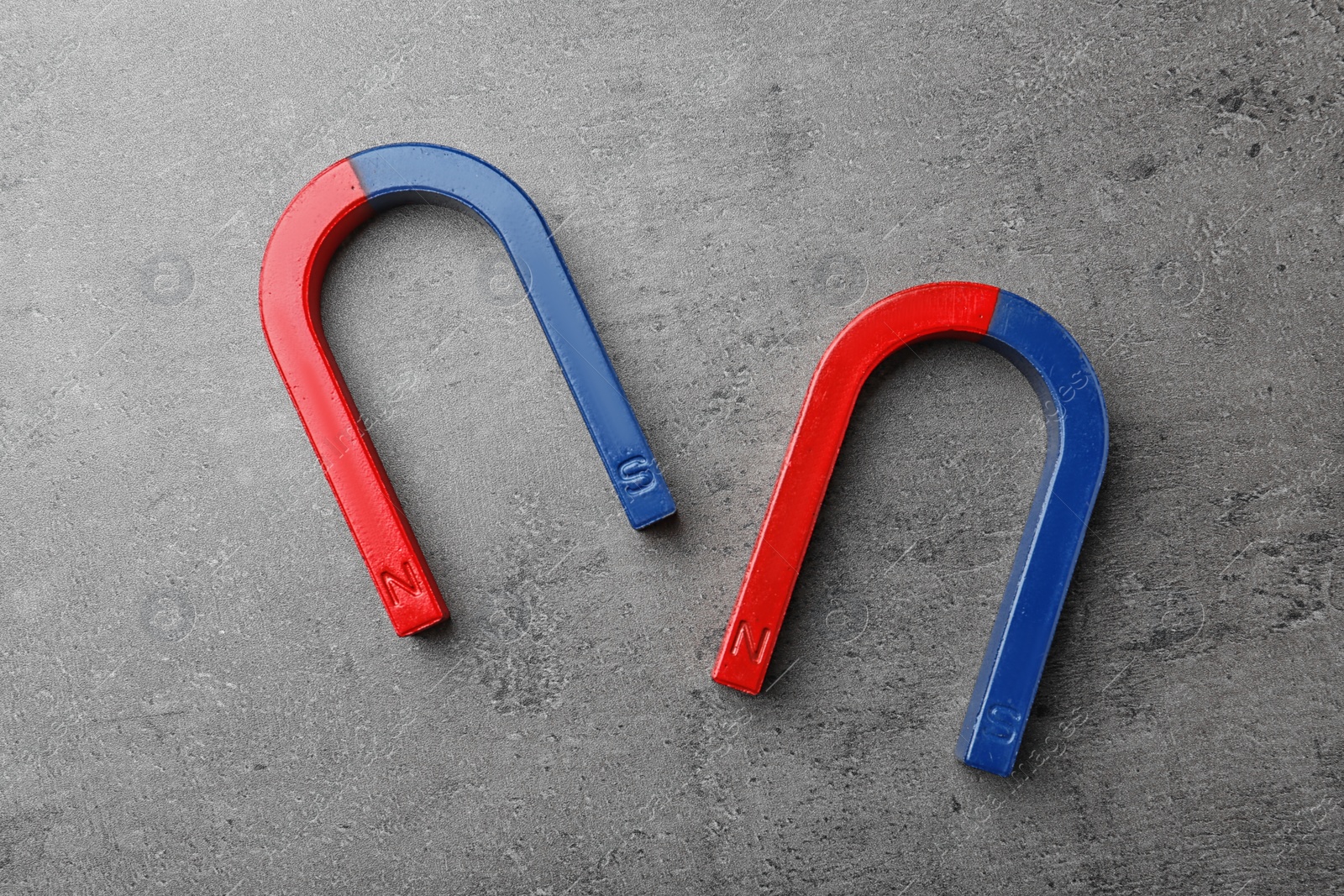 Photo of Red and blue horseshoe magnets on grey background, top view