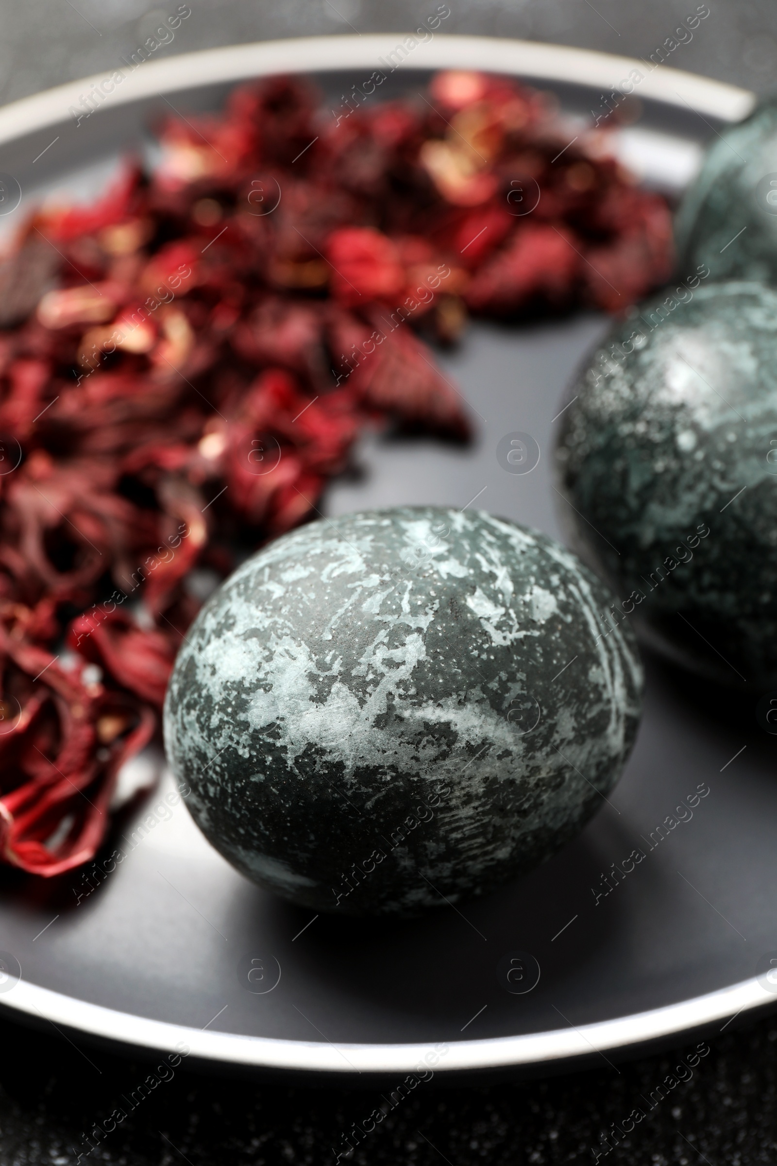 Photo of Naturally painted Easter eggs on black table, closeup. Hibiscus used for coloring