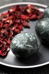 Photo of Naturally painted Easter eggs on black table, closeup. Hibiscus used for coloring