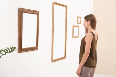 Photo of Young woman viewing exposition in modern art gallery