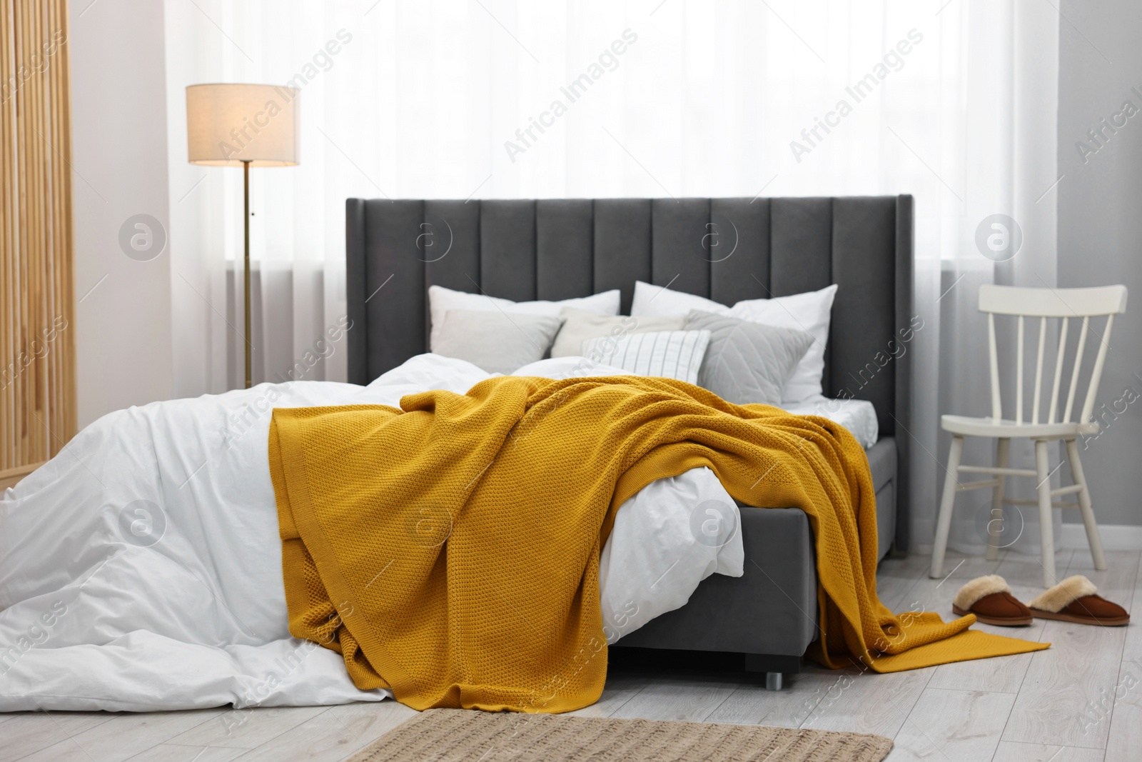 Photo of Bright plaid on bed in stylish bedroom