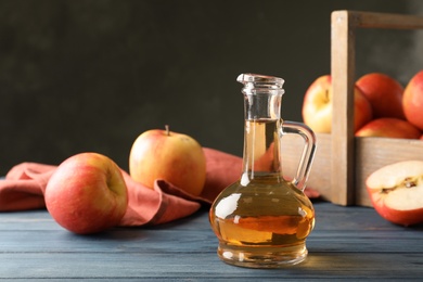 Photo of Composition with jug of apple vinegar on table. Space for text