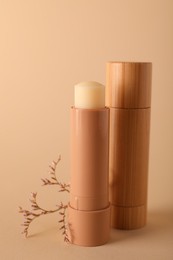 Lip balms on beige background. Cosmetic product