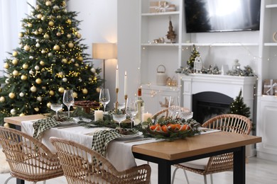 Photo of Christmas table setting with festive decor and dishware in living room