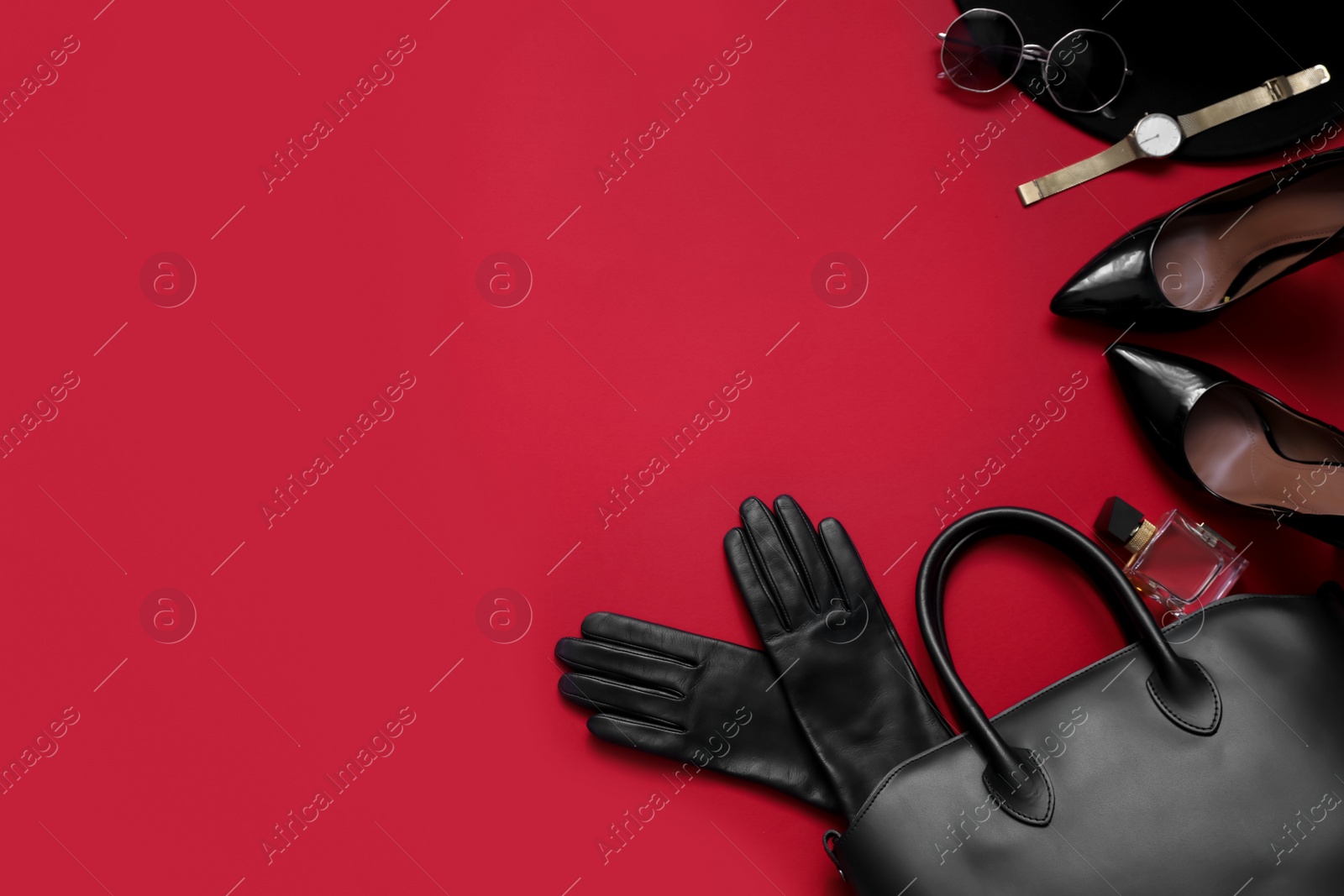 Photo of Flat lay composition with stylish black leather gloves, shoes and accessories on red background. Space for text