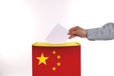 Woman putting her vote into ballot box decorated with flag of China against white background, closeup