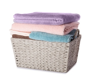 Wicker laundry basket with clean towels on white background