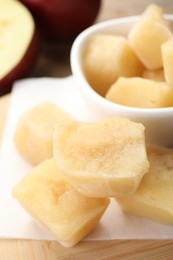 Photo of Frozen apple puree cubes and ingredient on wooden table, closeup