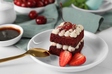 Piece of delicious red velvet cake with fresh berries served on white table, closeup