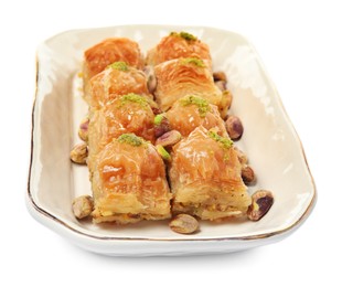 Plate of delicious baklava with pistachio nuts on white background