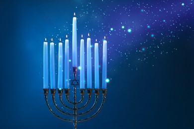 Hanukkah celebration. Menorah with burning candles on blue background, closeup. Space for text