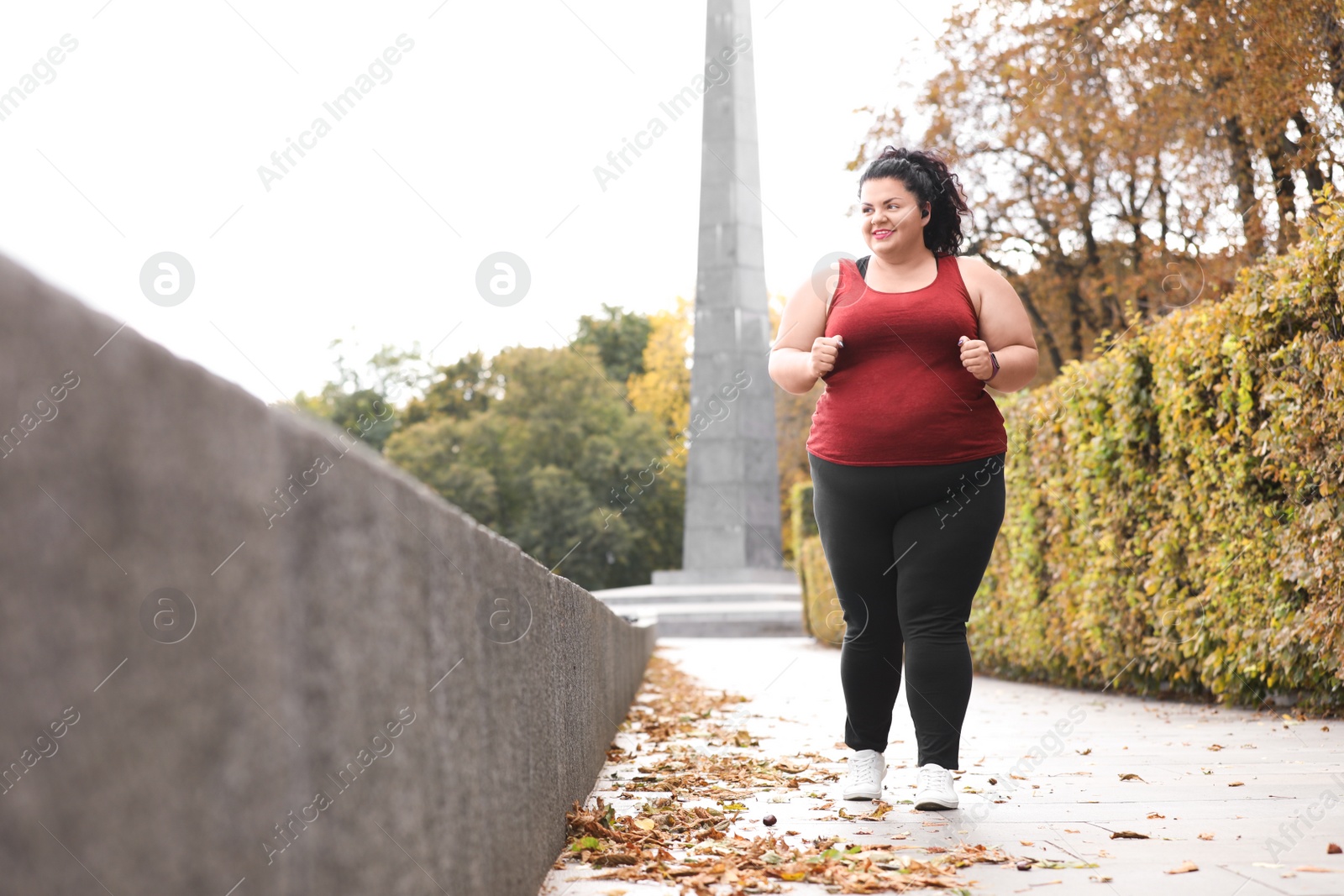 Photo of Beautiful overweight woman running in park. Fitness lifestyle