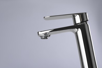 Single handle water tap on grey background. Space for text