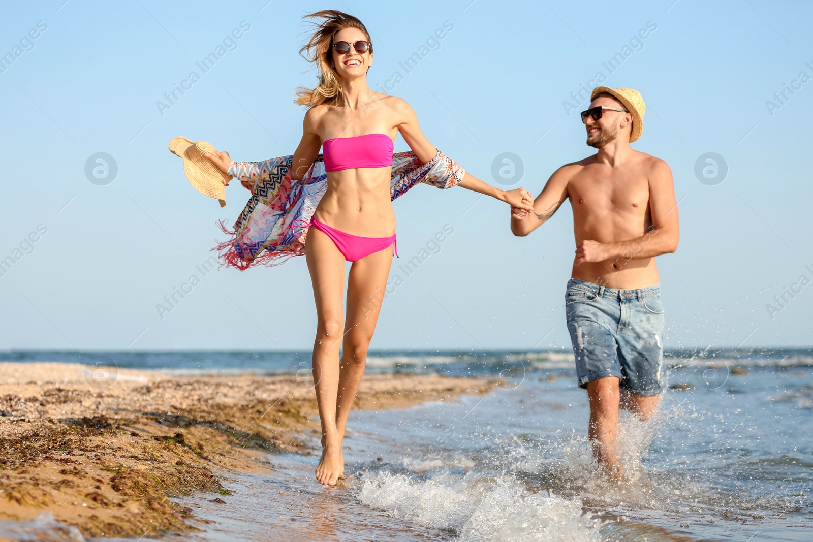 Photo of Young couple spending time together on beach