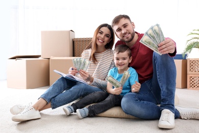 Photo of Happy family with money on floor at home