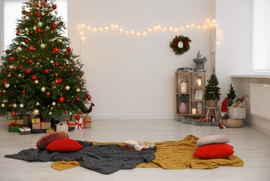 Photo of Cosy TV area with beautiful fir tree, snacks, Christmas gifts and accessories in room