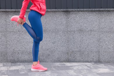 Photo of Woman in gym clothes doing exercises on street, closeup. Space for text