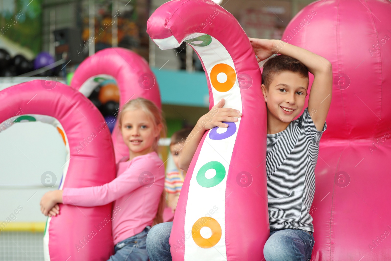 Photo of Cute little children playing at indoor amusement park