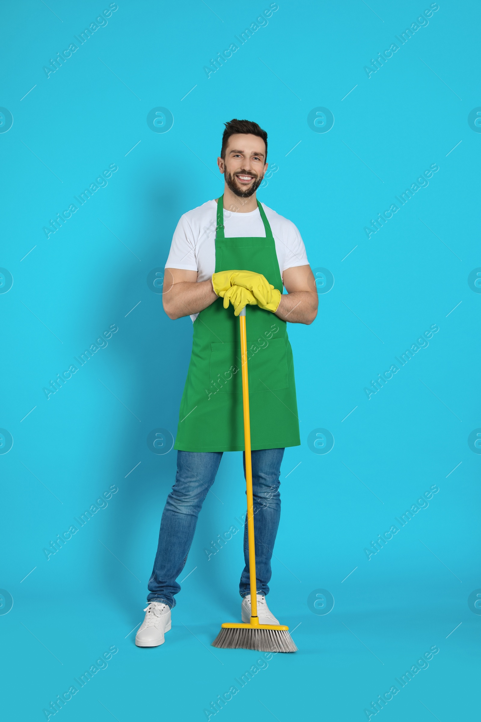 Photo of Man with yellow broom on light blue background