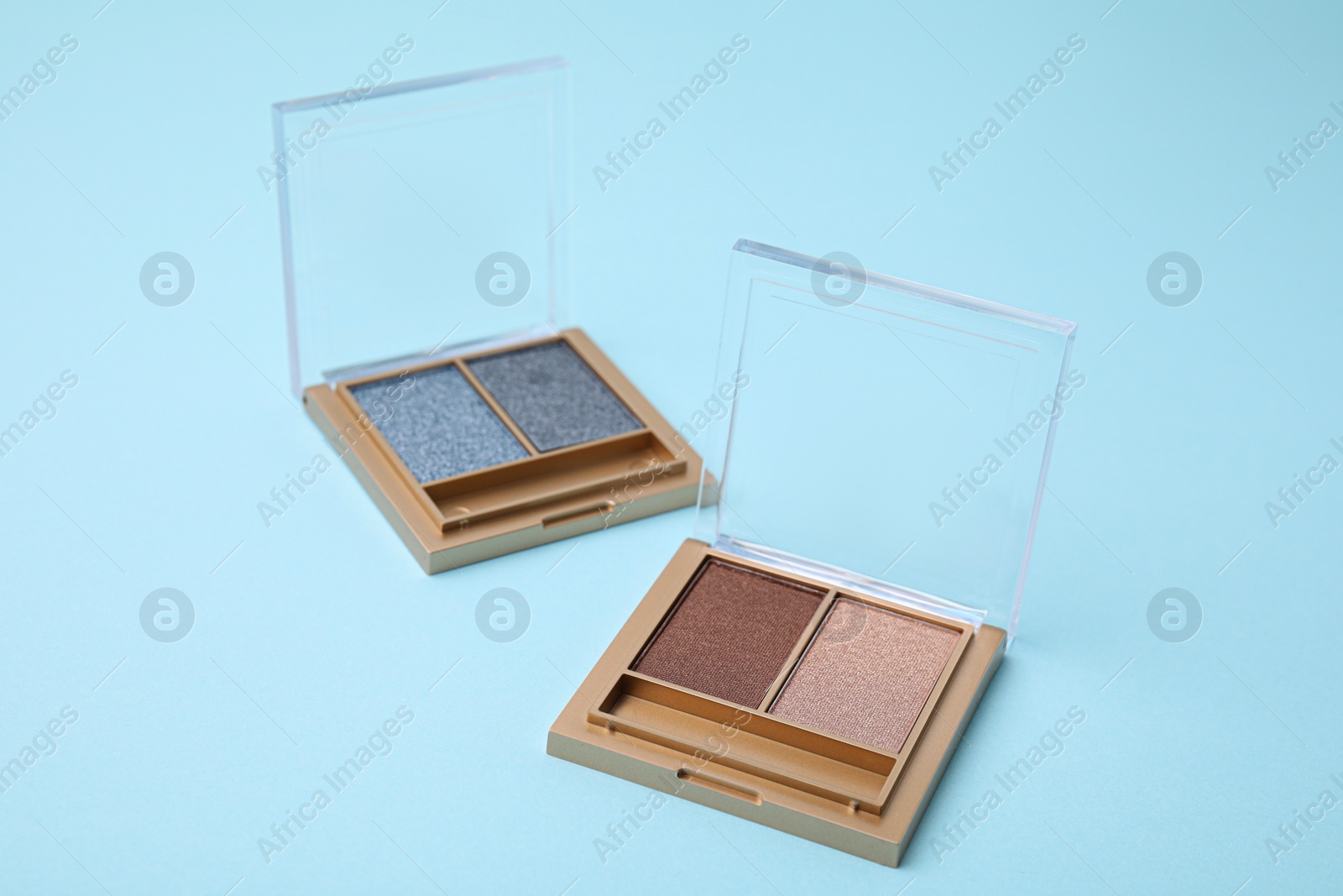 Photo of Beautiful eye shadow palettes on light blue background