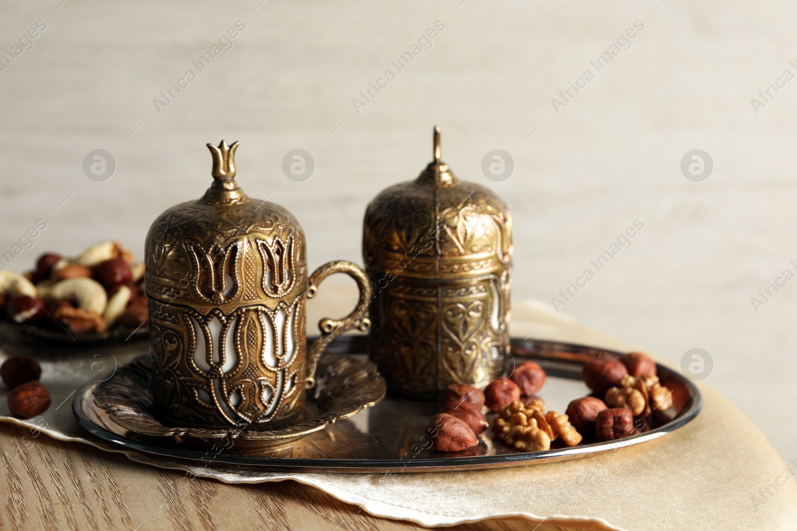 Photo of Tea and nuts served in vintage tea set on wooden table, space for text