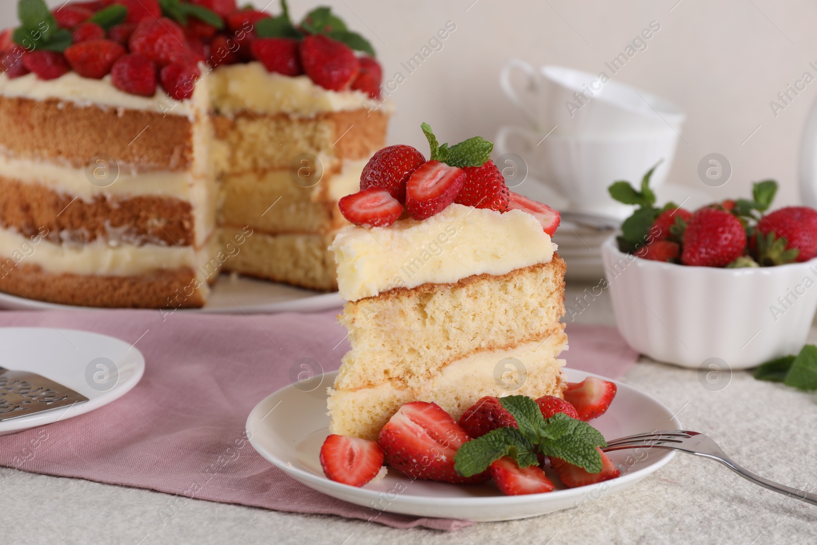 Photo of Piece of tasty cake with fresh strawberries and mint on white table