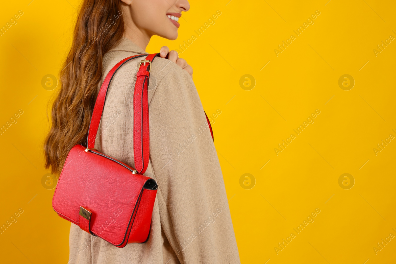 Photo of Woman with stylish bag on yellow background, closeup. Space for text