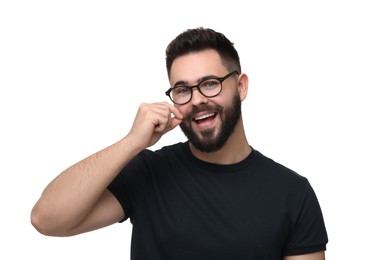 Happy young man touching mustache on white background