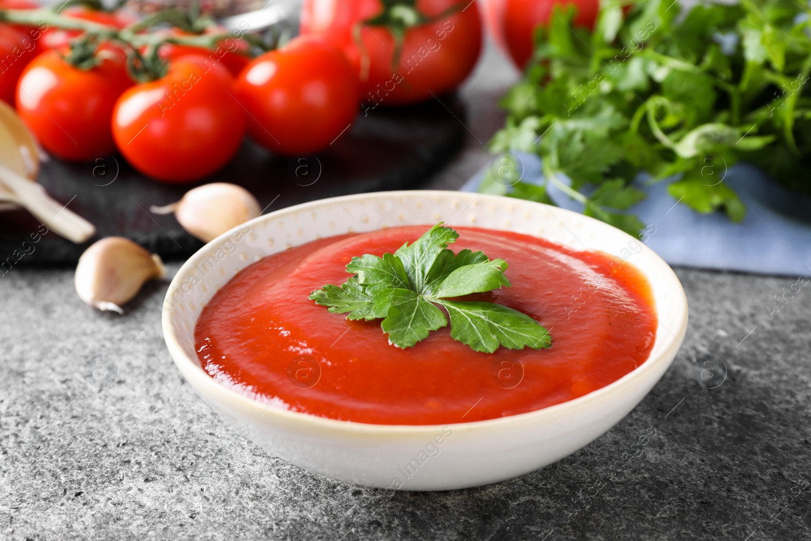 Photo of Delicious fresh tomato sauce on grey table, closeup