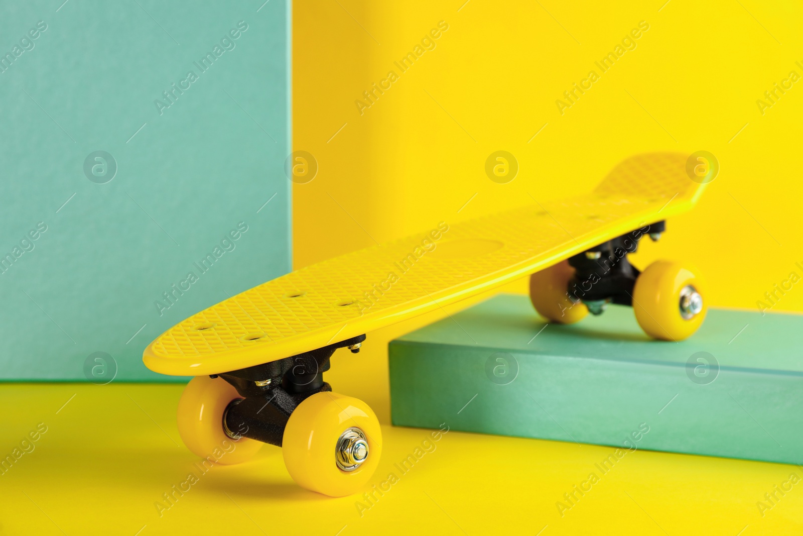 Photo of Yellow skateboard on color background. Sport equipment