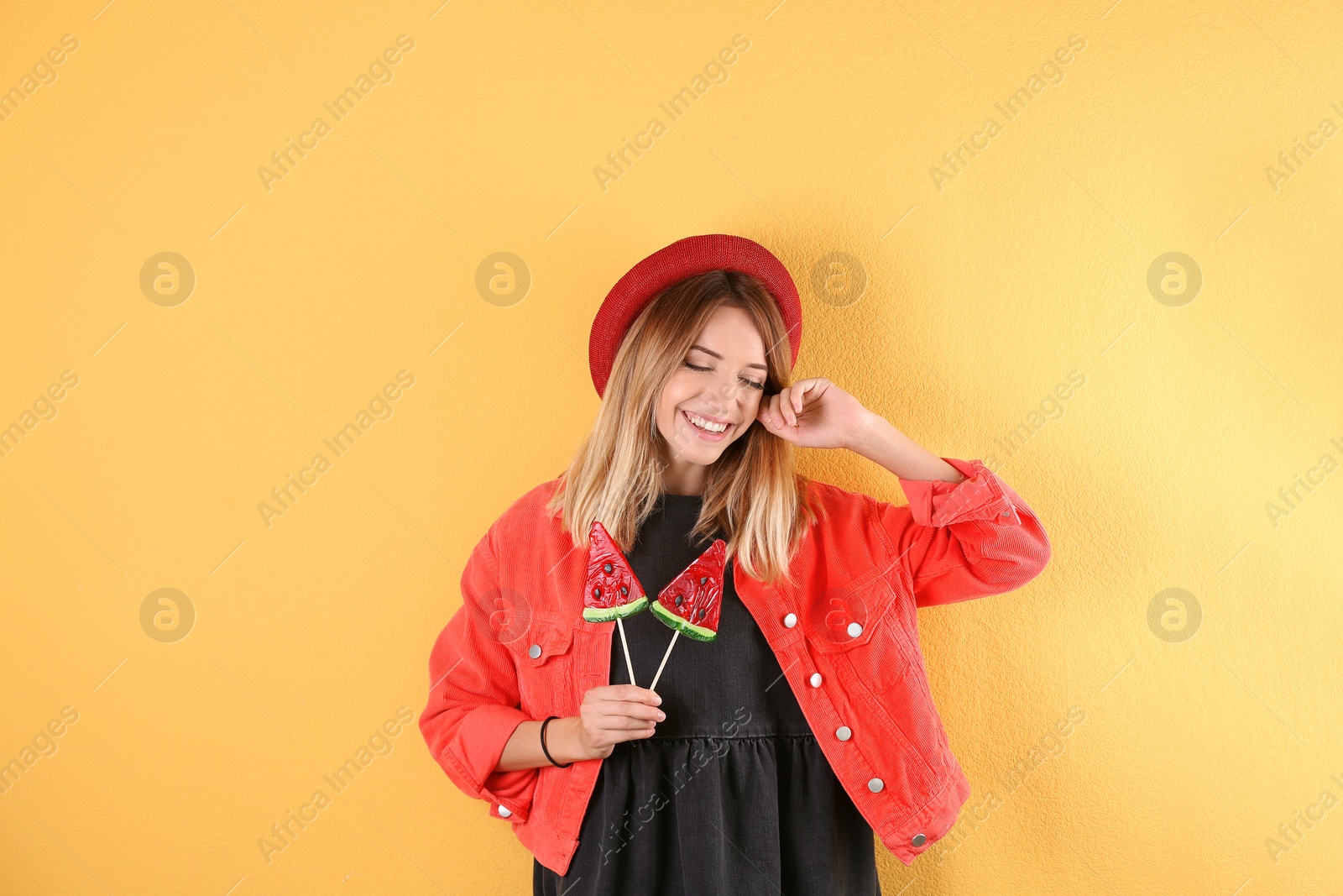 Photo of Young pretty woman with candies on colorful background