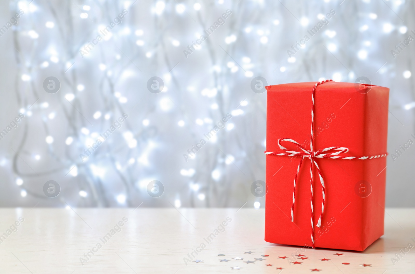 Photo of Christmas gift on table against blurred background