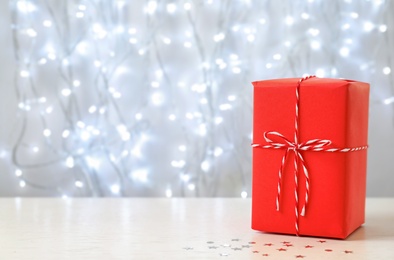 Photo of Christmas gift on table against blurred background