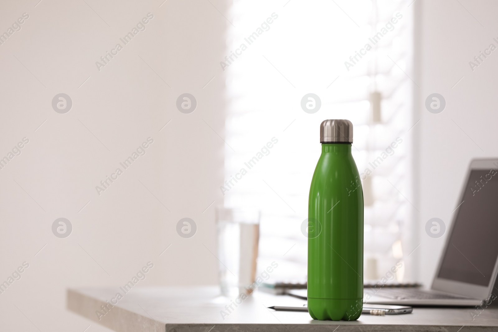 Photo of Thermo bottle on table in modern office