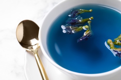 Photo of Organic blue Anchan in cup on table, closeup. Herbal tea