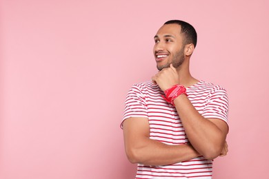 Portrait of happy African American man on pink background. Space for text