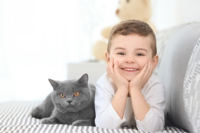 Photo of Cute little child with cat at home