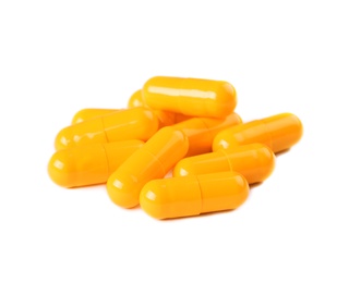 Photo of Pile of orange pills on white background