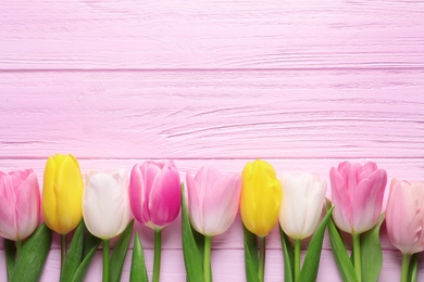 Photo of Flat lay composition of beautiful spring tulips on wooden background, space for text. International Women's Day