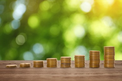 Image of Stacked coins on wooden table against blurred background. Investment concept