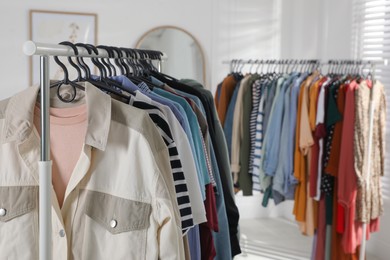 Racks with stylish clothes indoors. Fast fashion