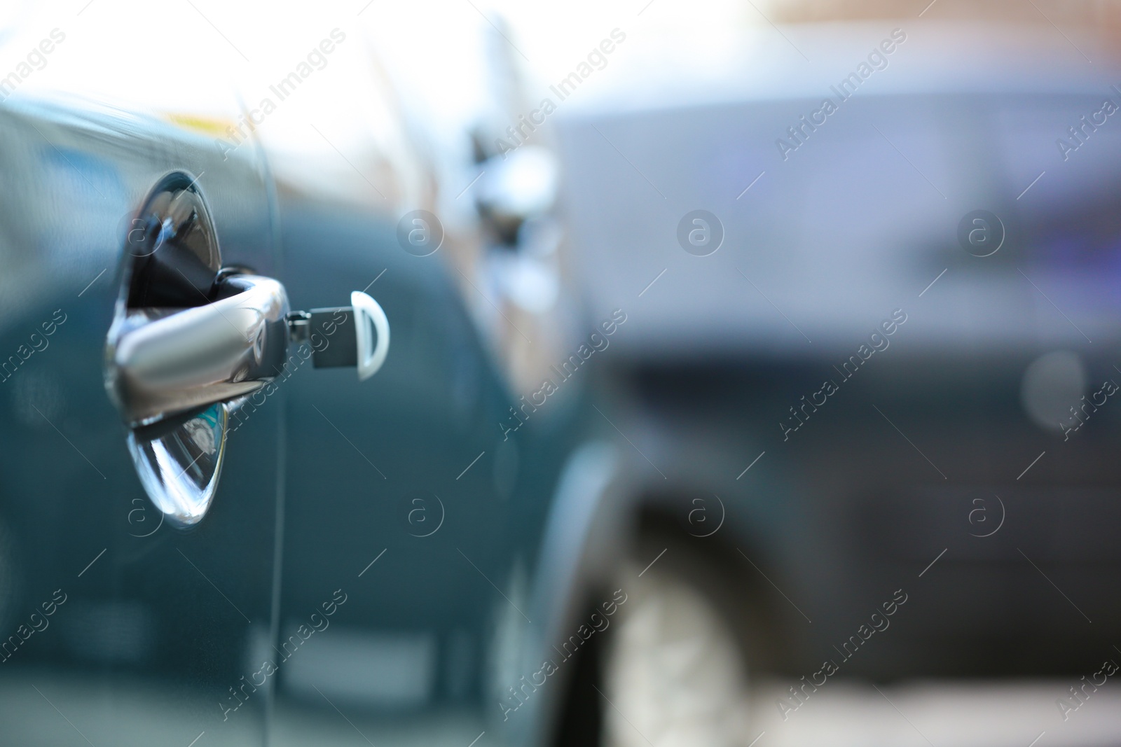 Photo of Closeup view of car door with key in lock. Space for text