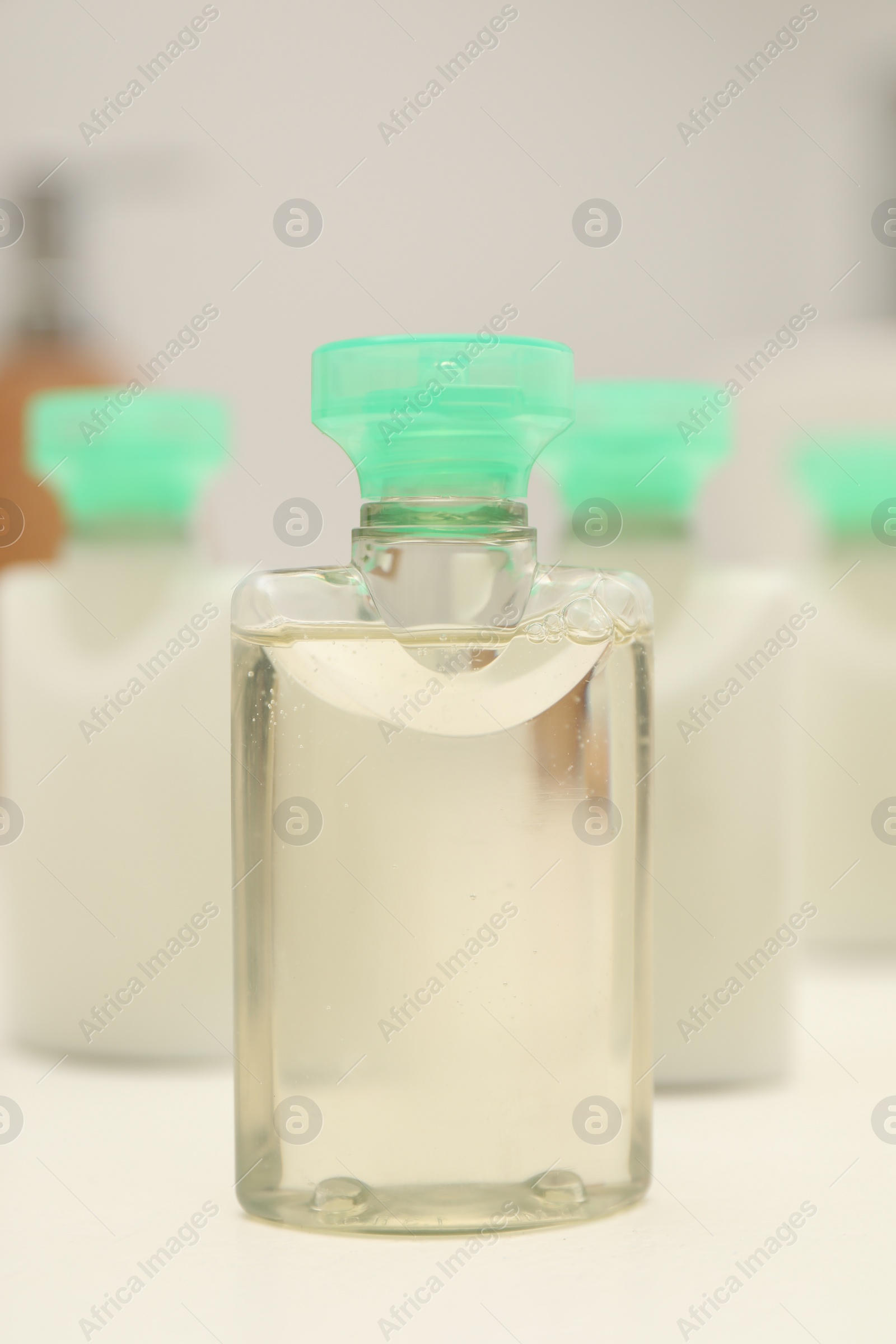 Photo of Mini bottles of cosmetic products on white table, closeup