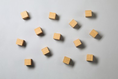 Photo of Many empty wooden cubes on light grey background, flat lay